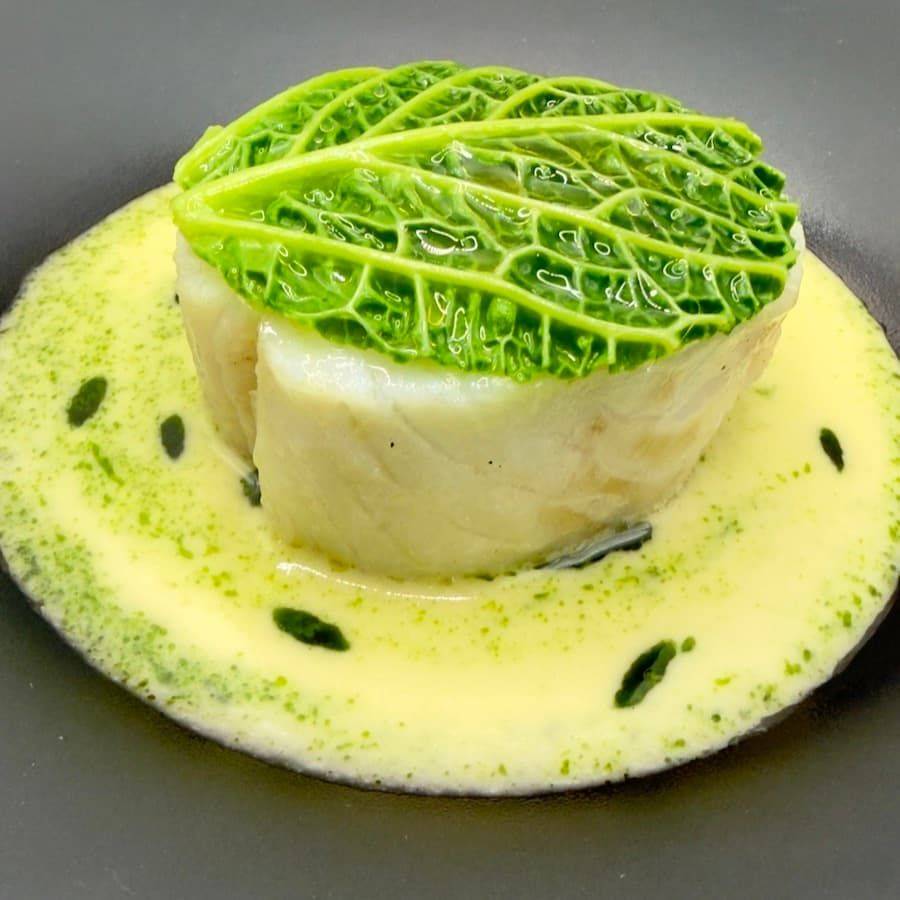 Cabbage-wrapped fish in herb velouté