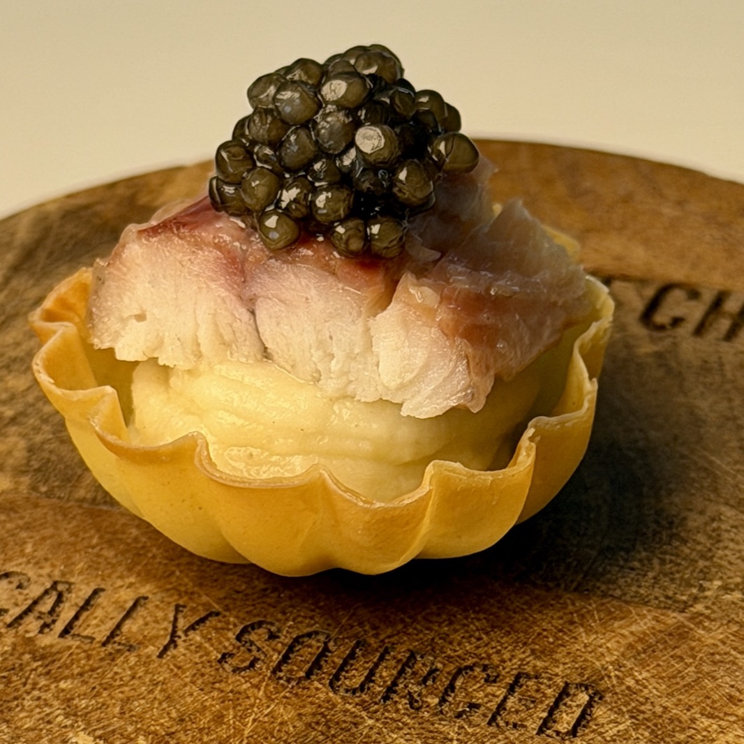 Tartlet with caviar on wooden board